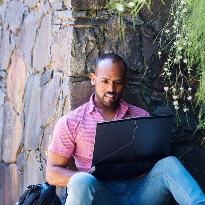 Student in garden with laptop