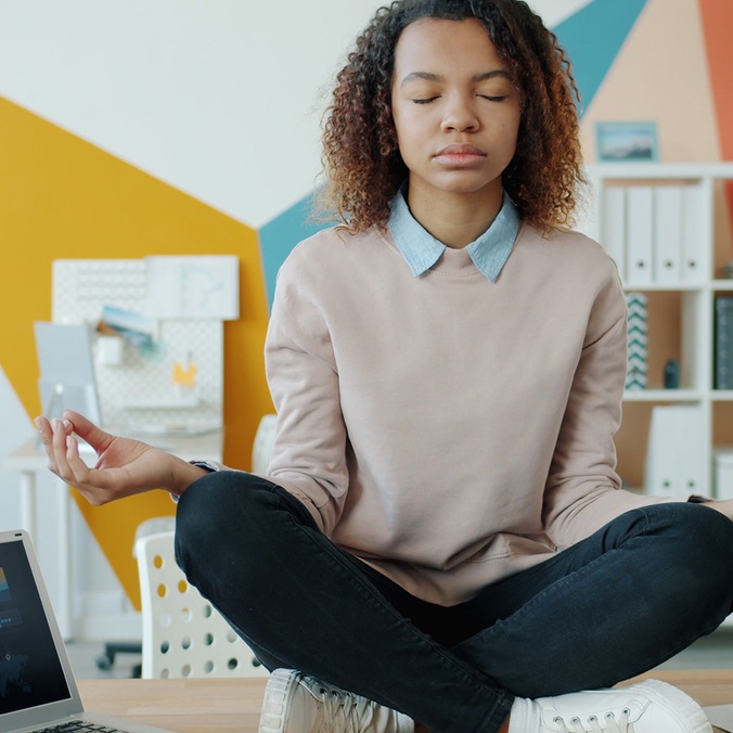 girl sitting on desk meditating