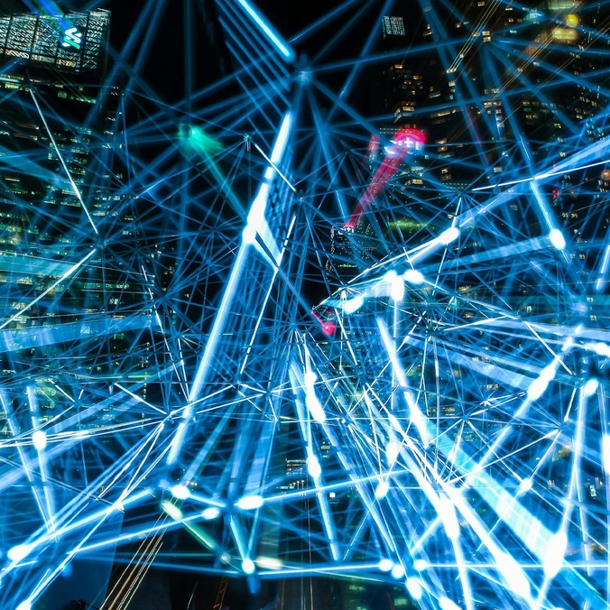 Image of blue lights connecting with a night city landscape