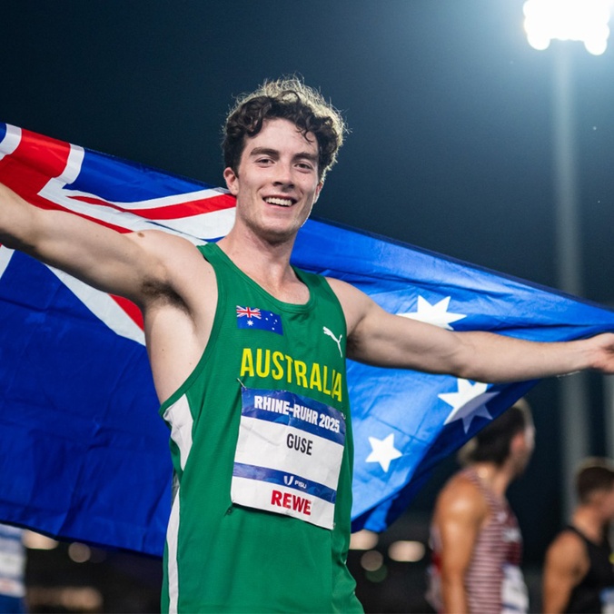 Man in green sports uniform holding Australian flag