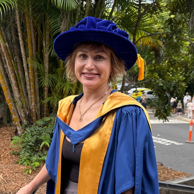 Student in academic robes smiling at camera