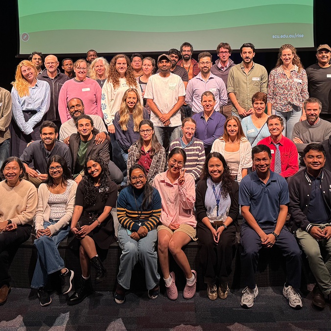 Large group of people smiling on a stage