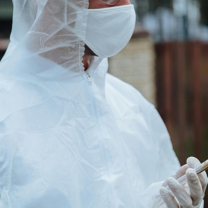 Person is PPE holding sample in tube