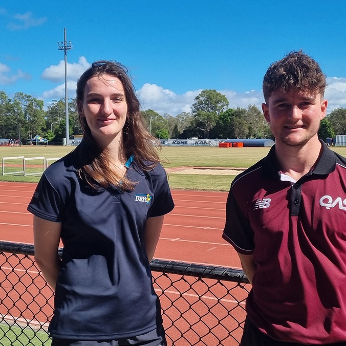A woman and man standing in front of running track
