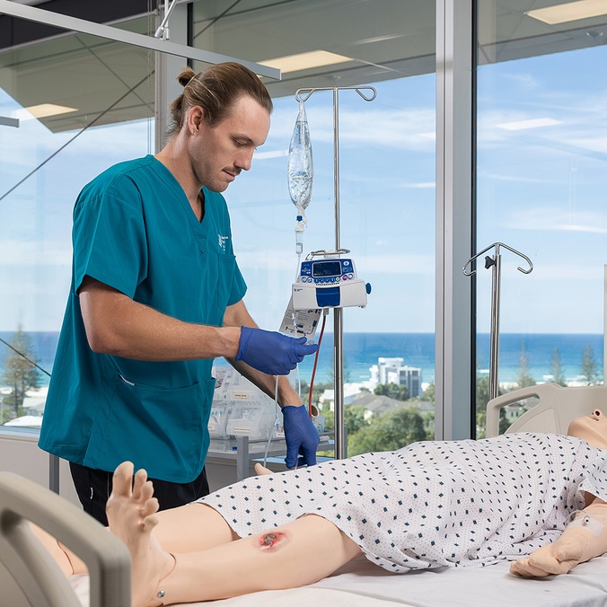 Student working on nursing sim doll