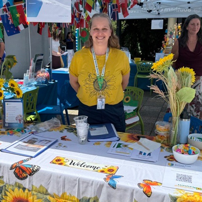 Woman standing at market stall with sunflowers