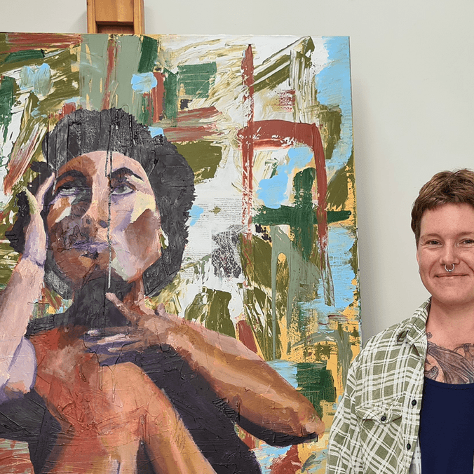 Art and design student standing with painting of woman