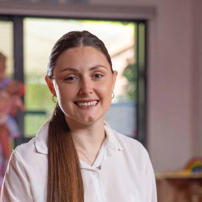 Woman smiling at camera with white collared shirt