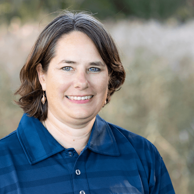 Professor Kirsten Benkendorff in blue polo smiling in a field.