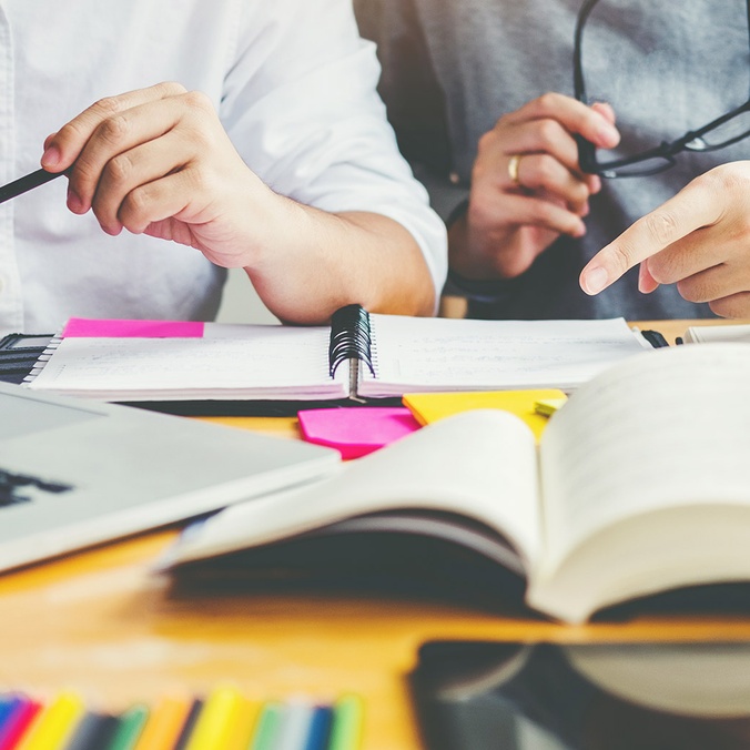Researchers sitting at a desk with computer and books open