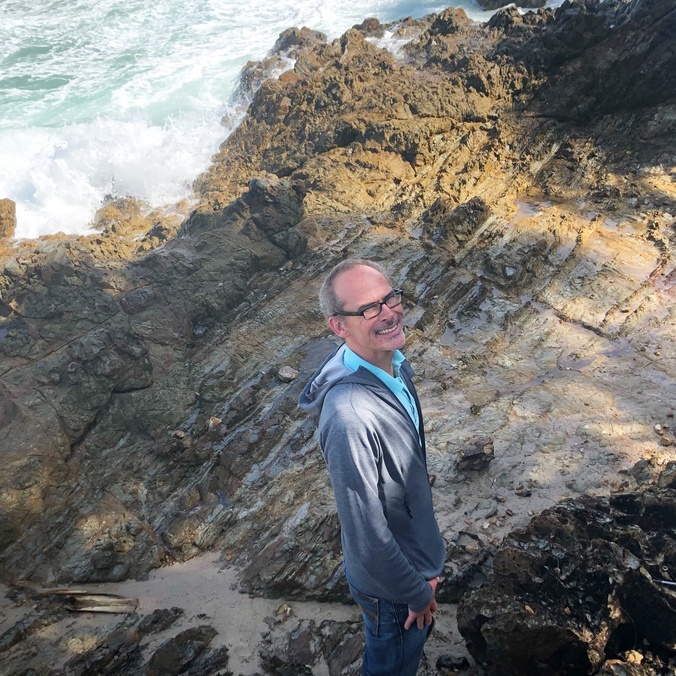 A man standing on a rock shelf
