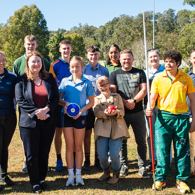 A group of people on a sports oval looking at the camera