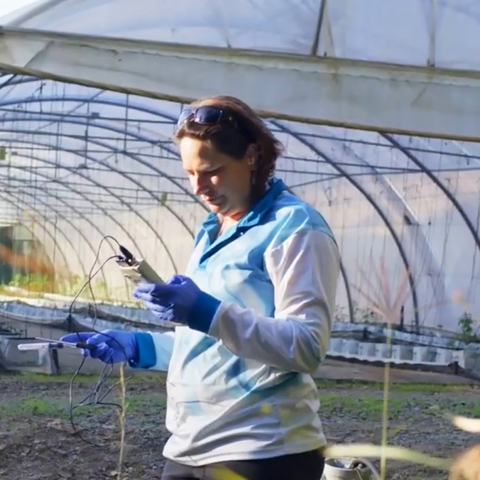 Kirsten Benkendorff sampling in front of greenhouse