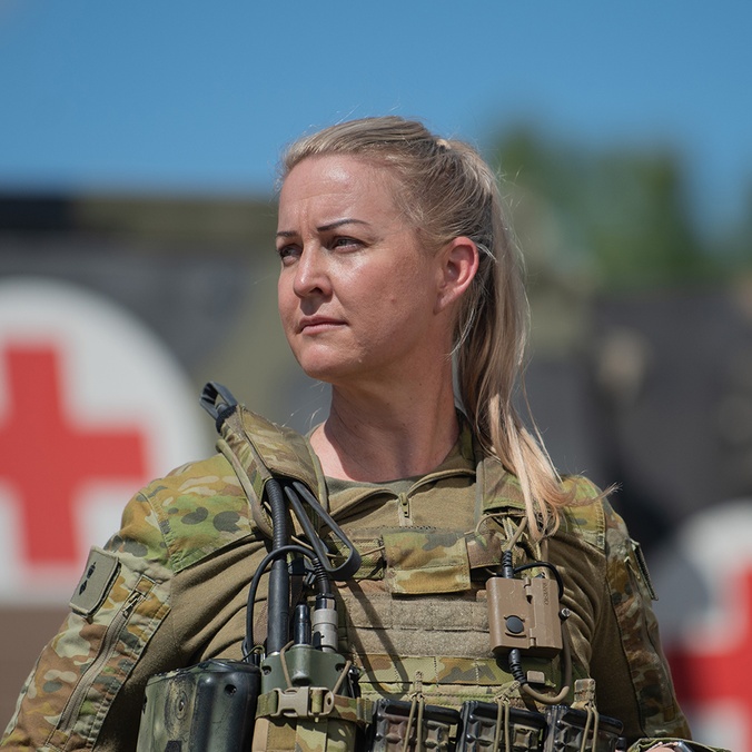 An army nurse standing in front of a medical truck