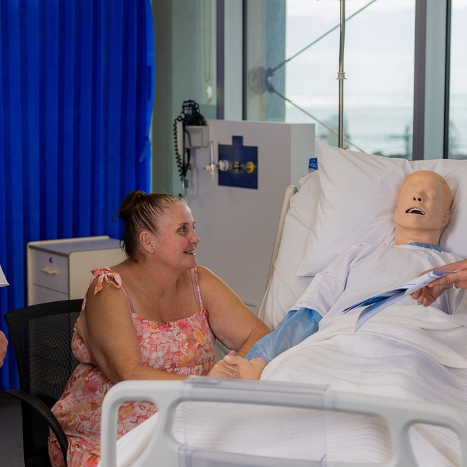 A patient in hospital with carer, nurse and academic