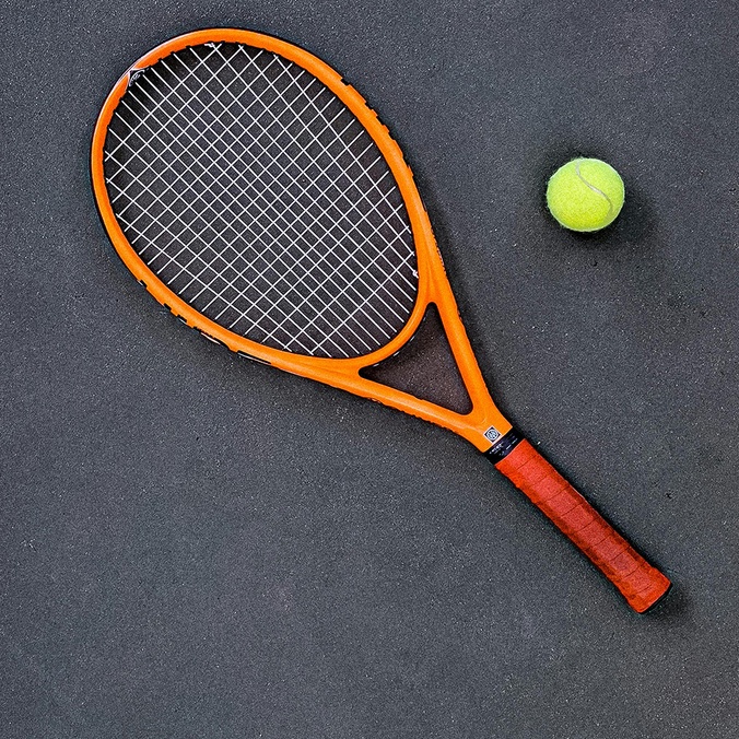 Tennis racquet and ball on ground of tennis court