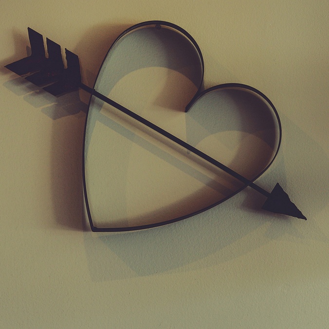 Metal cupid heart with arrow on wall