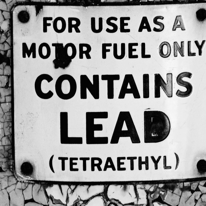 black and white danger sign warning of lead in motor fuel