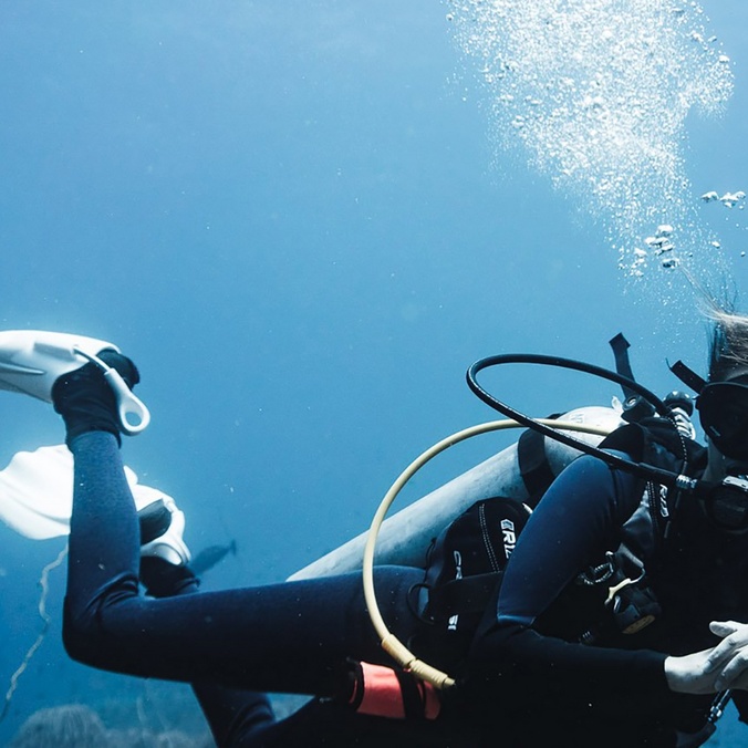 A scuba diving under the water with a manta ray
