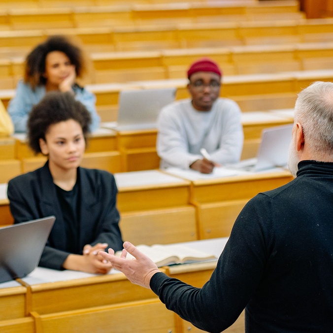 A lecturer standing in front of students in a university lecture room