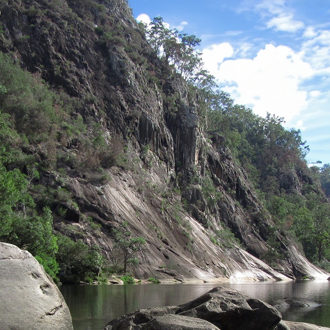 A steep valley with large boulders and a river running through it