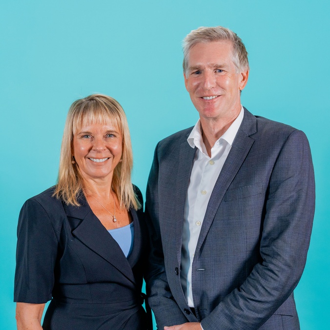 Woman and man in front of blue background