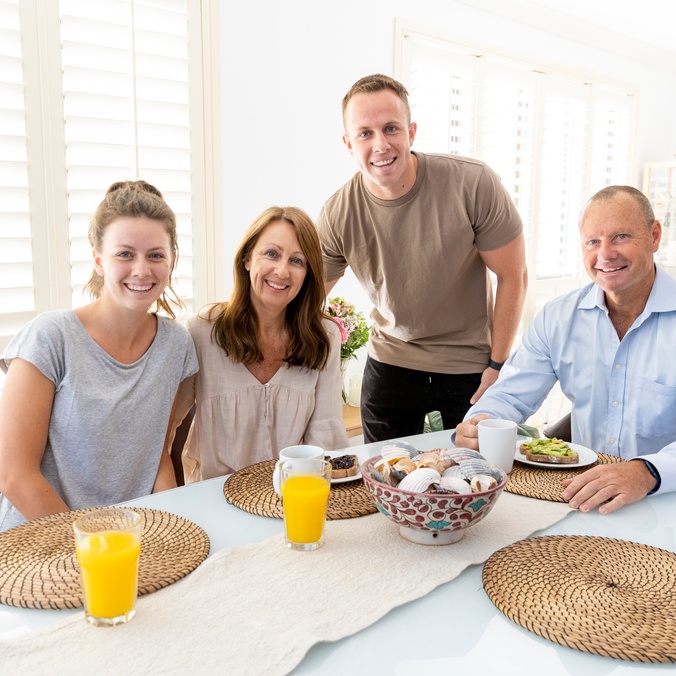 Family sharing breakfast looking at the camera