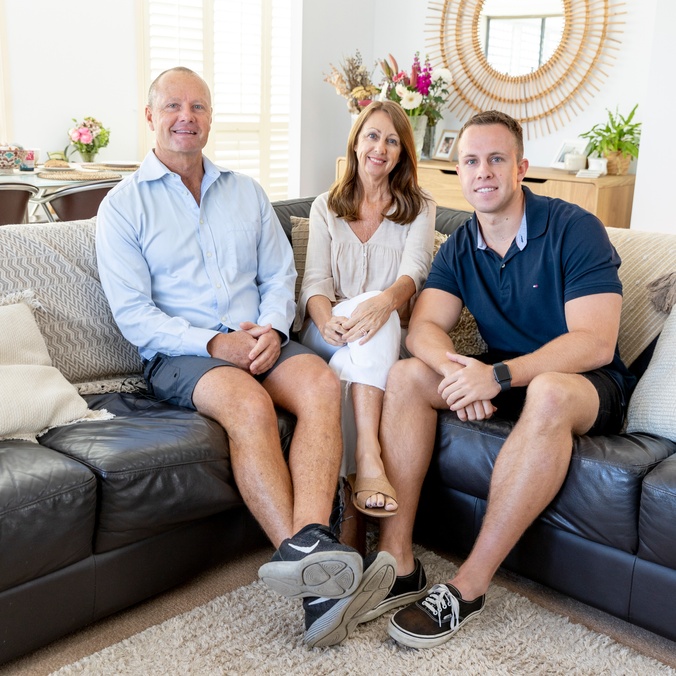 Family sitting on the couch looking at the camera