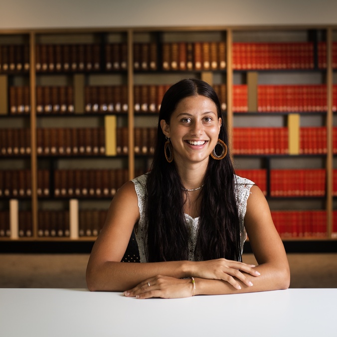 Student sitting in front of law books
