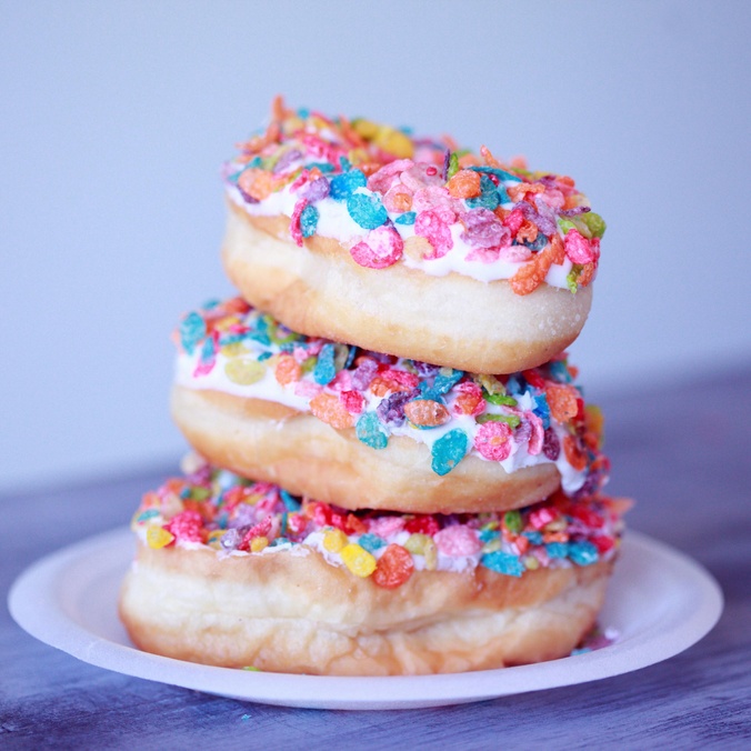 Three doughnuts stacked on a plate