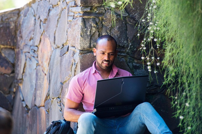 Student in garden with laptop