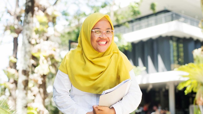 student in front of library building