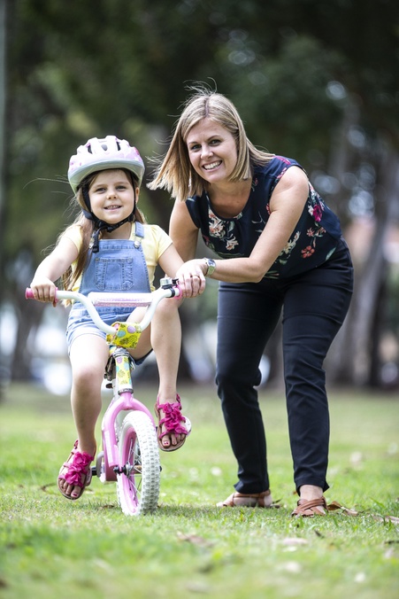 mother teaching daughter on bike