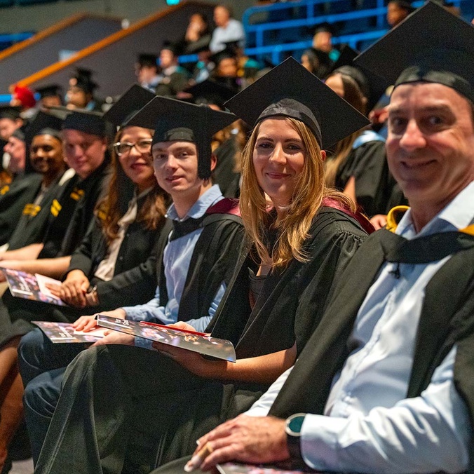 Students in the theatre prepared for graduation.