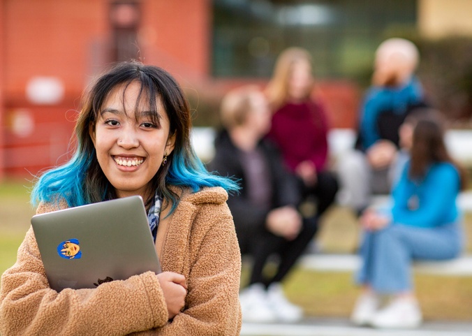 Student portrait holding laptop
