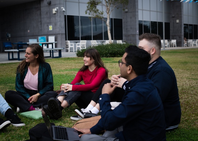 A group of students sit and laugh together.