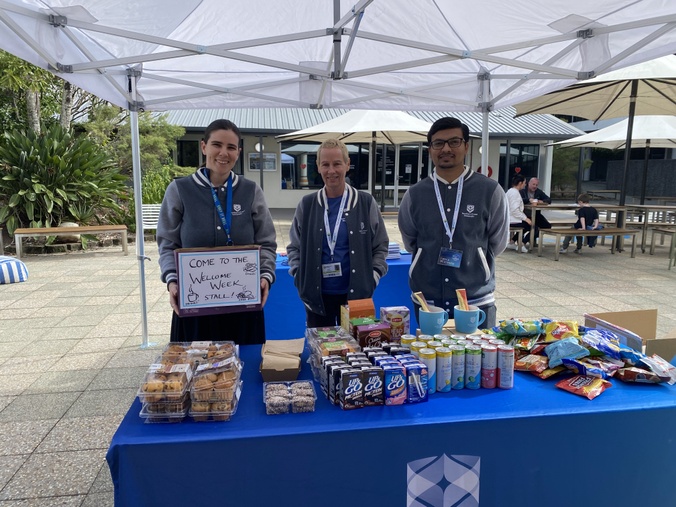 3 people at a Welcome Week stall