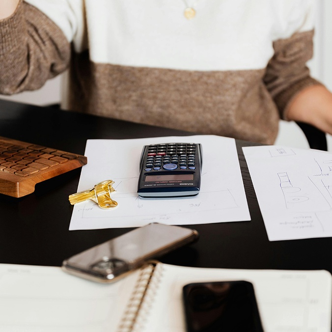 student at desk with calculator