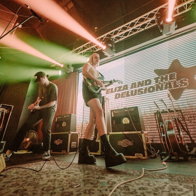 student with guitar on stage