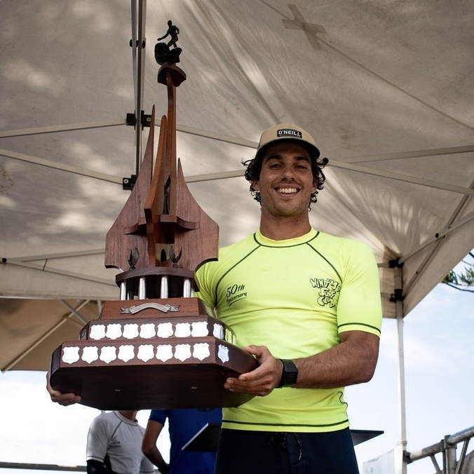 Elite athlete surfer holding trophy
