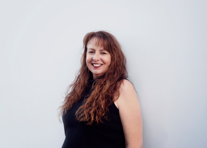 Theresa Mitchell from Agape Outreach standing in front of white wall