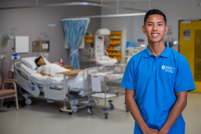John standing in front of hospital bed