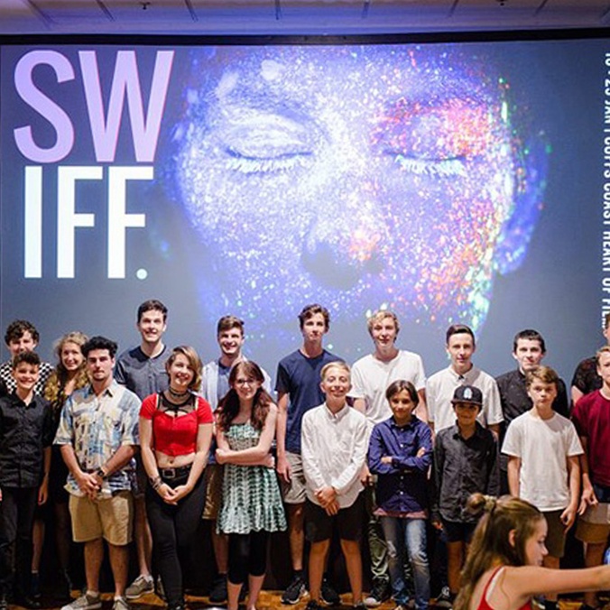 Nextwave / SWIFF finalists stand in front of a large banner for swift festival