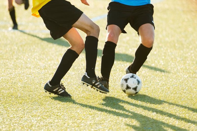 Two students kicking a ball