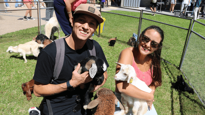 2 students holding baby farm animals