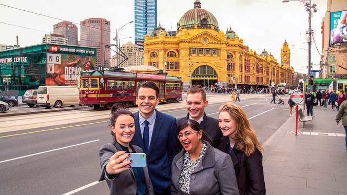 Group of student posing for selfie outside Flinders Street Station in Melbourne