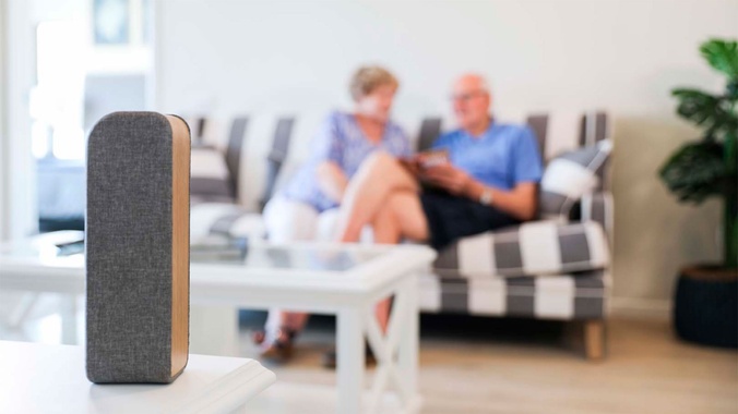 Smart device in foreground with blurred elderly couple in background