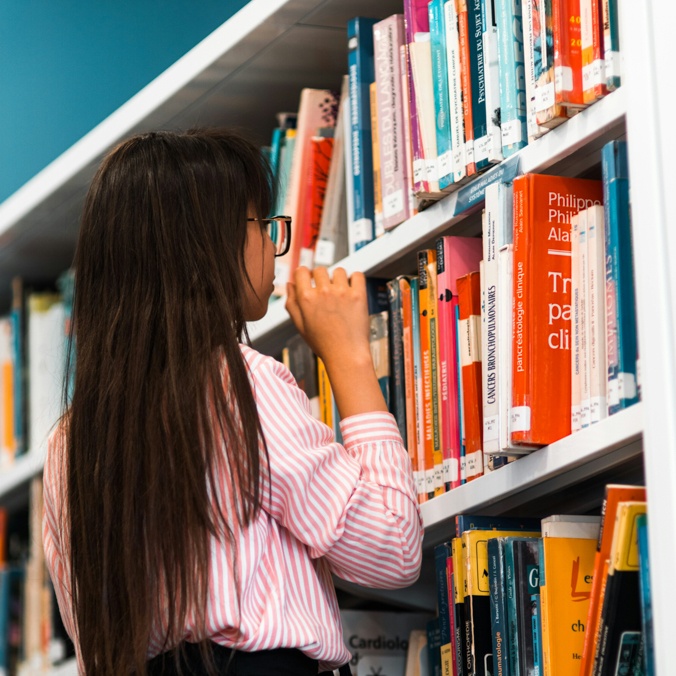 Girl looking at library books