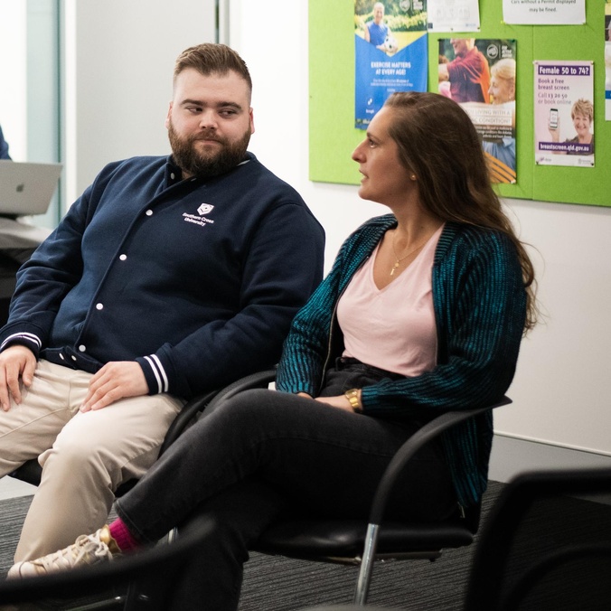 Two people sitting on armchairs talking