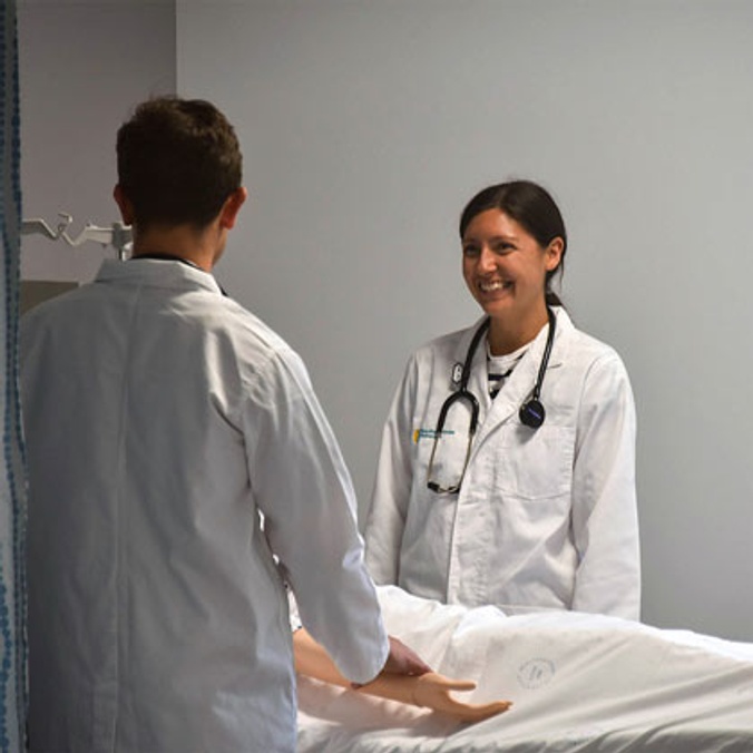 2 students standing by hospital bed